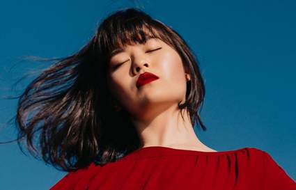 woman with hair down in against a blue sky