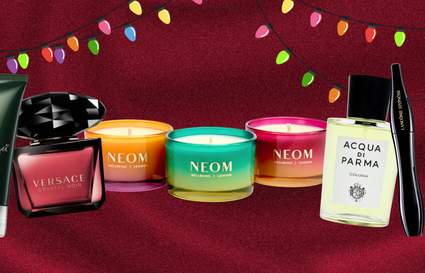 beauty products on a burgundy background with multi-coloured string lights on the top border