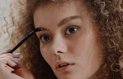 woman combing eyebrows