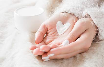 Cupped hands holding cream in heart shape